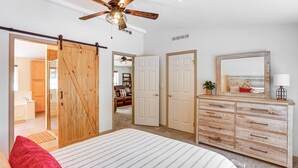 A bedroom with a bed, a dresser, a ceiling fan, and a sliding door leading to another room. - Bayfield Retreat, 9 Mi to Vallecito Reservoir! (Bayfield)