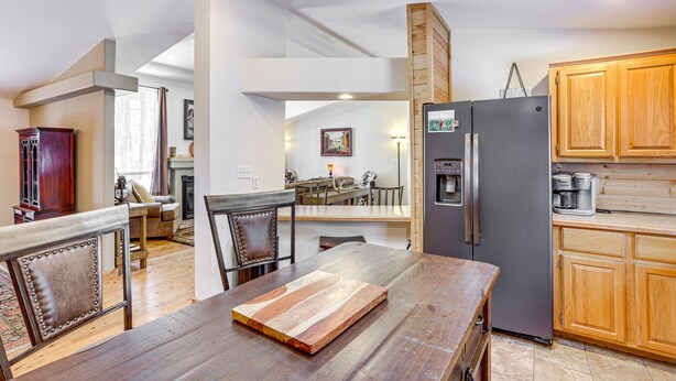 A spacious kitchen with wooden cabinets, a refrigerator, and a dining area with a wooden table and chairs. - Bayfield Retreat, 9 Mi to Vallecito Reservoir! (Bayfield)