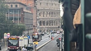 A street view with a prominent historical building, a bus, and various vehicles. - Colosseo House (Rome)