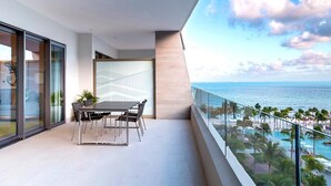 A balcony with a dining table and chairs, overlooking a pool and beach area. - VIP luxury for Christmas at Cancun's 5 diamond resort!  (Cancun)