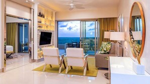 A modern living room with a large TV, comfortable seating, a balcony with a view, and a ceiling fan. - VIP luxury for Christmas at Cancun's 5 diamond resort!  (Cancun)