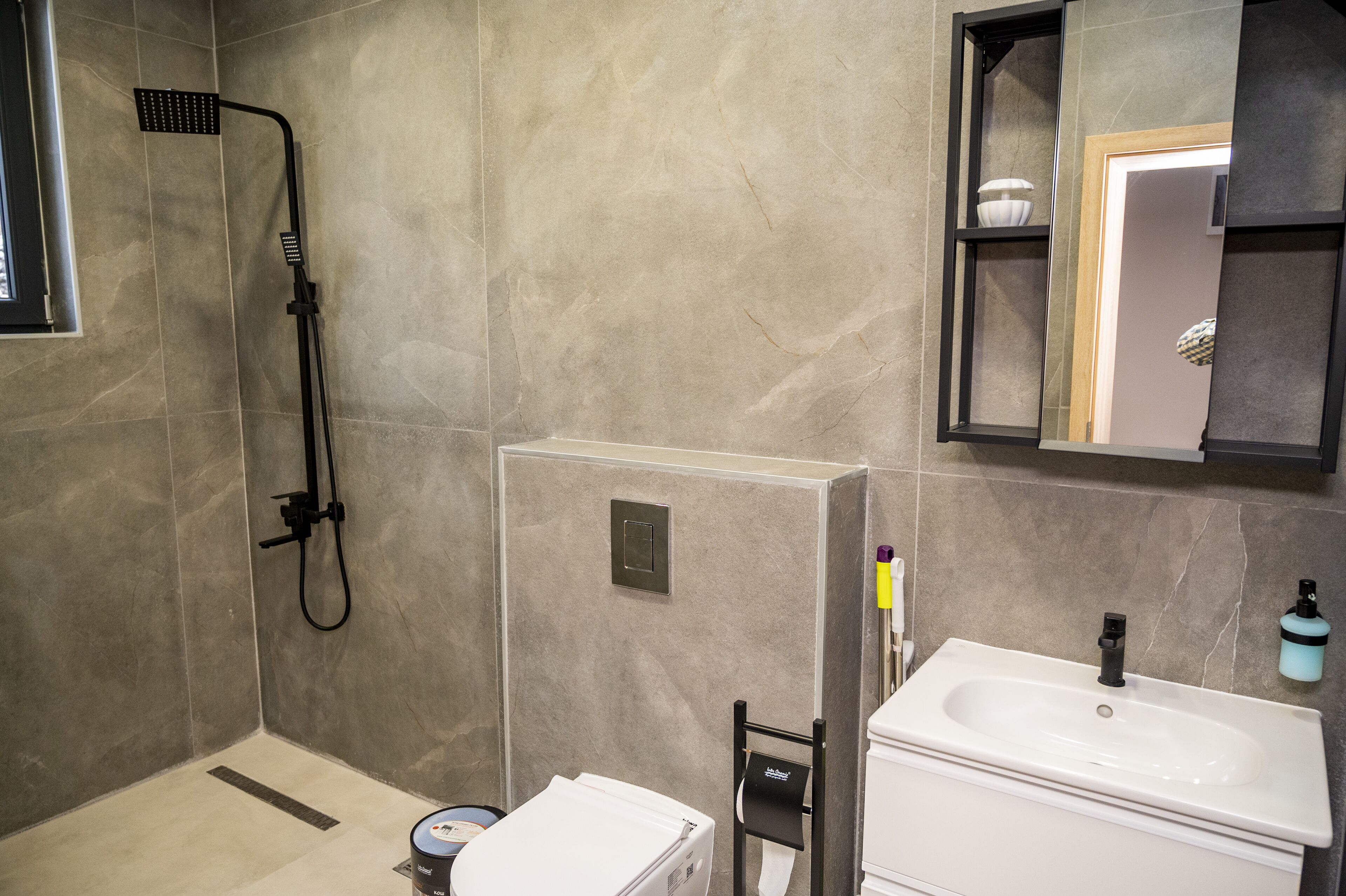 A modern bathroom with a shower, sink, and mirror.