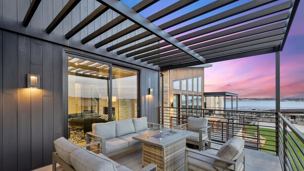 Un patio moderno al aire libre con asientos y vista al frente marítimo.
