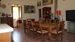 A dining room with a wooden table and chairs, a cabinet, a television, and artwork on the walls. - In the heart of Valdichiana historic Tuscan farmhouse, swimming pools for exclusive use (Toscana)
