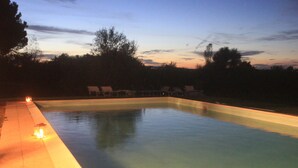 A rectangular swimming pool with a paved edge and a few lounge chairs along the side. - In the heart of Valdichiana historic Tuscan farmhouse, swimming pools for exclusive use (Toscana)