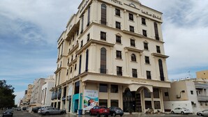 A multi-story hotel with a classic architectural style, featuring a prominent entrance with a large archway and a signboard. - Sansa Hotel (Jeddah)