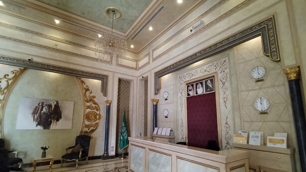A luxurious lobby with ornate decorations, a grand chandelier, and a reception desk. - Sansa Hotel (Jeddah)
