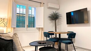 Een moderne woonkamer met een bank, een salontafel en een eettafel met stoelen.