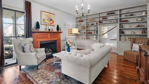 A living room with a fireplace, a sofa, a coffee table, and a bookshelf.