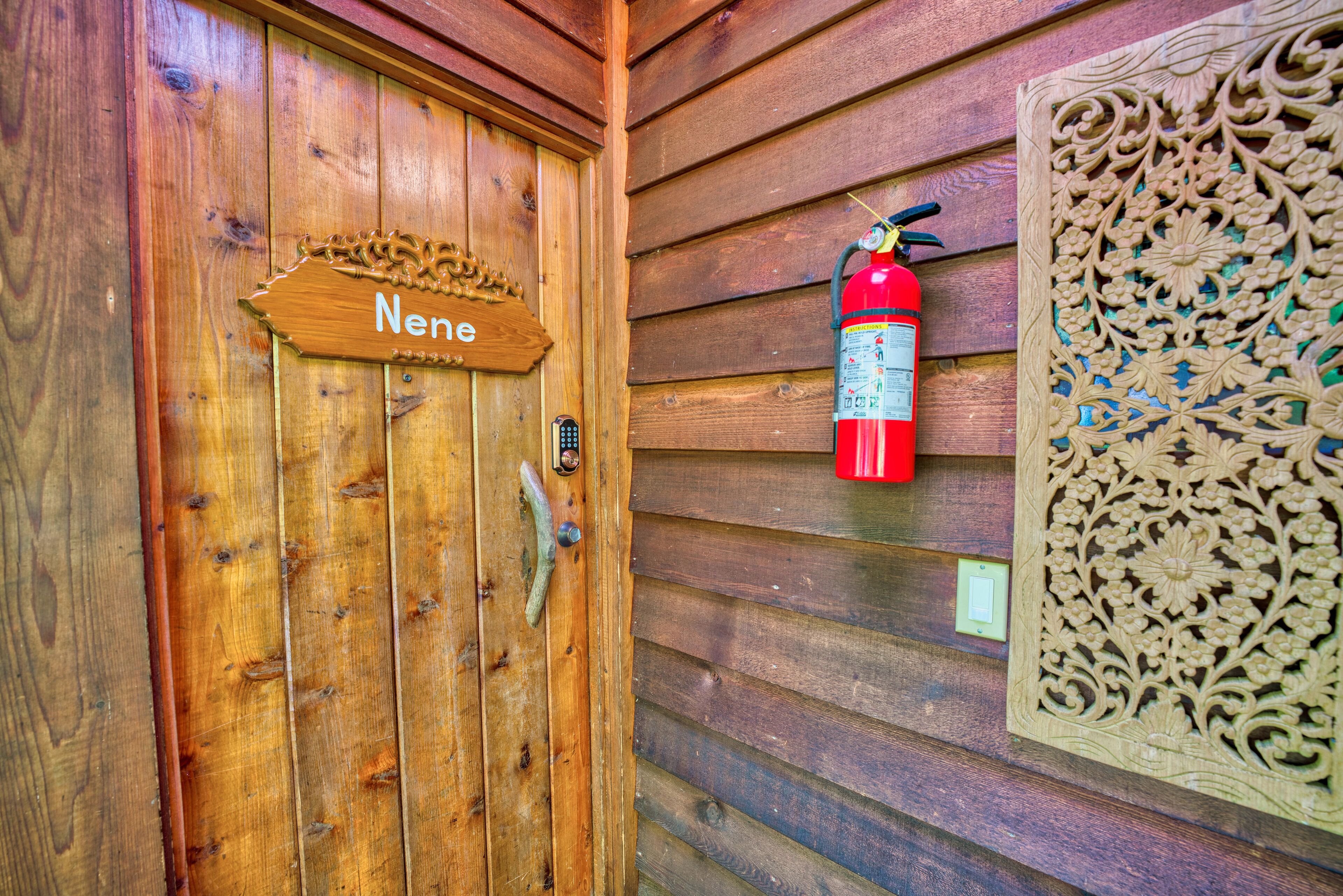 A wooden door with a sign reading 'Nene,' a fire extinguisher mounted on the wall, and a decorative panel.