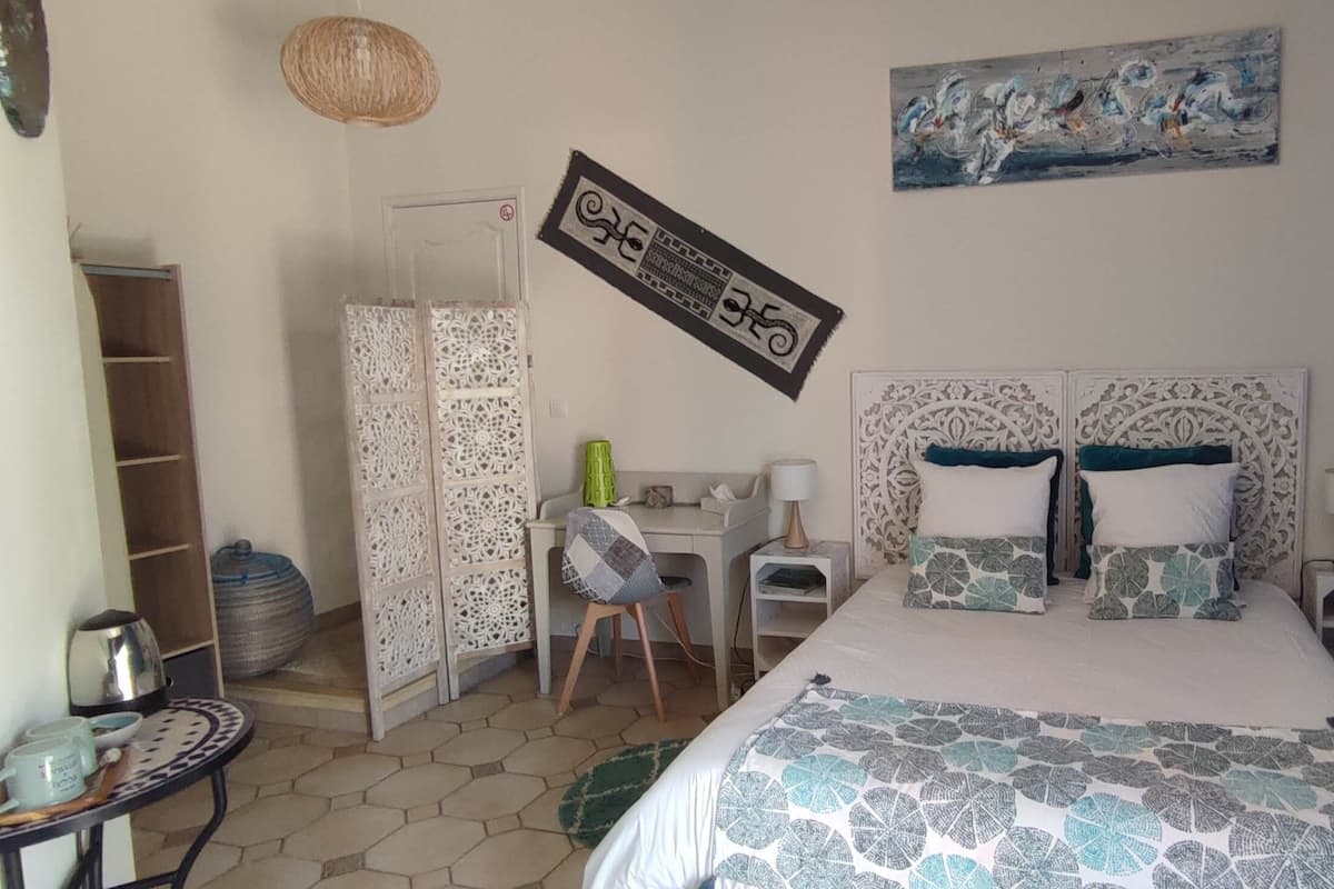 Ein Schlafzimmer mit Bett, Schreibtisch, Stuhl und Kleiderschrank.