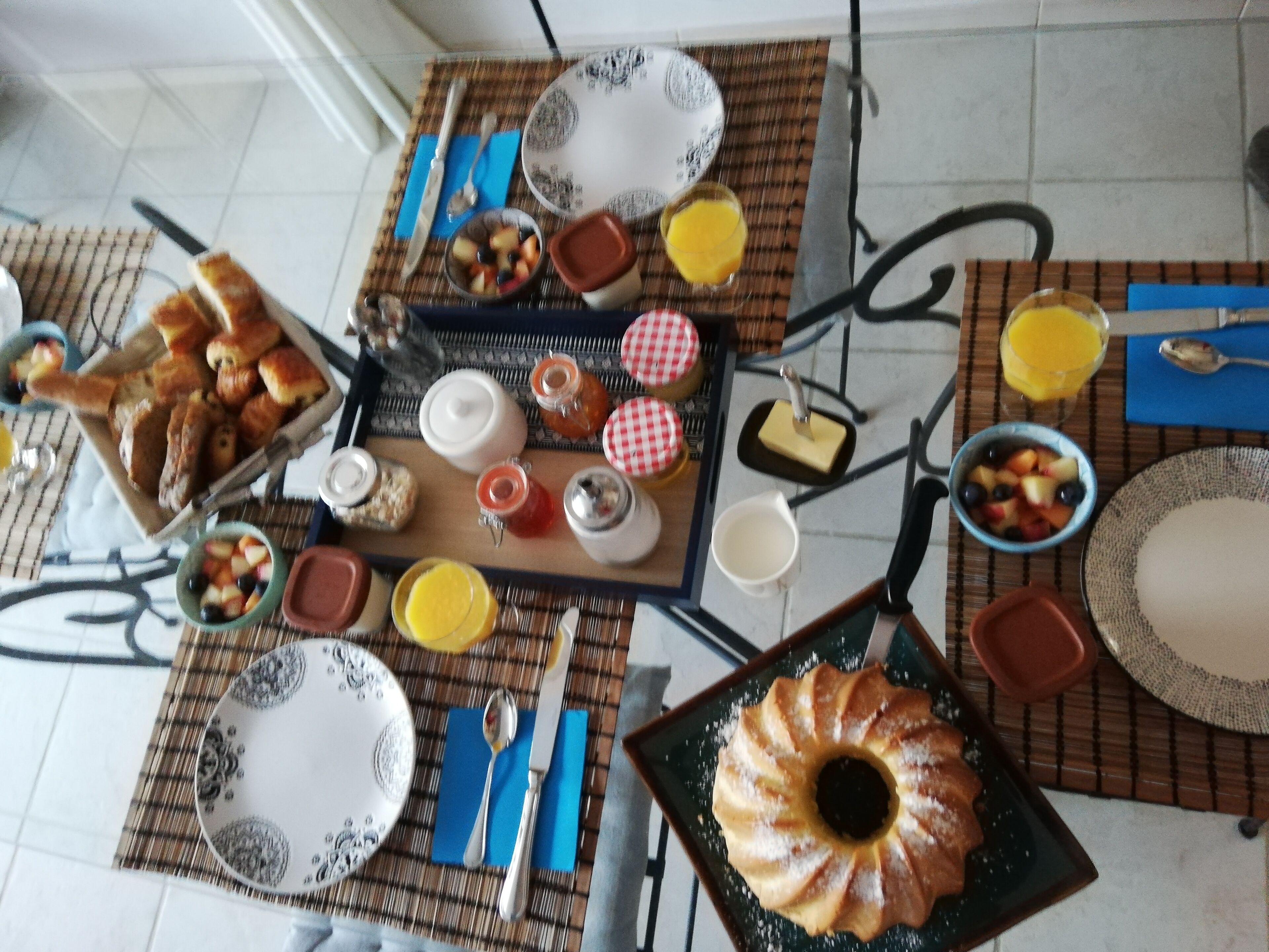 Una mesa de desayuno con diferentes alimentos, utensilios y una tetera.