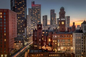 A cityscape with a mix of modern and historic buildings, including a prominent clock tower labeled "KIMPTON." - City Suite - Rooftop Spa - Balcony - Skyline View (Manchester)