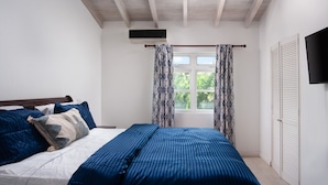 A bedroom with a bed, a window with curtains, a ceiling fan, and a TV on the wall. -  A charming blend of comfort and sophistication in this near-the-beach townhouse (Holetown)