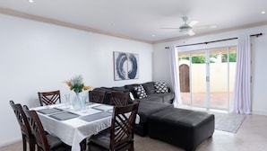 A dining area with a table set for four, a sofa, and a ceiling fan. -  A charming blend of comfort and sophistication in this near-the-beach townhouse (Holetown)