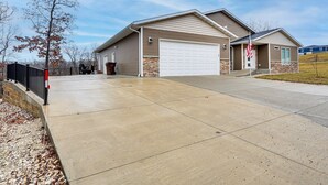 Ein zweigeschossiges Haus mit Garage, Auffahrt und kleinem Rasen.
