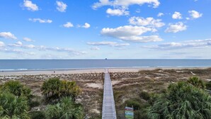 A beach with a wooden boardwalk leading to the shore, surrounded by vegetation. - Oceanview, Pet Friendly in Pelican Point (Saint Helena Island)