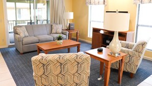 A living room with a sofa, two patterned armchairs, a coffee table, a lamp, and a television. - Port O'Call - Hilton Head 6/21/25-6/28/25 - HUGE DISCOUNT!!

 (Hilton Head Island)