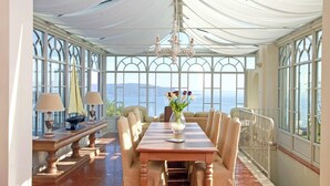 A sunlit dining area with a table, chairs, and a chandelier. - Villa Teodora in Toscolano-maderno (Toscolano Maderno)