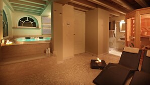 A spa room with a hot tub, a wooden sauna, and a seating area with candles. - Villa Teodora in Toscolano-maderno (Toscolano Maderno)
