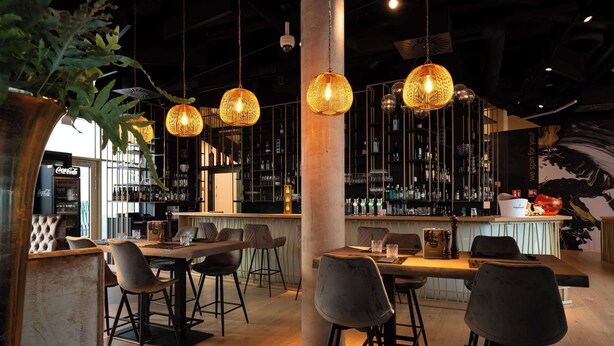 A modern bar area with hanging wicker lamps, a bar counter, and a seating area with stools and a table. - Best Western Hotel Spinnerei Linz (Linz)