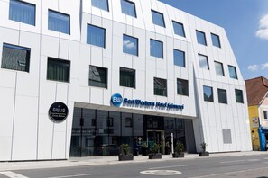 A modern hotel building with a clear entrance, a sign for 'Best Western Hotel Spinaci,' and a 'Da Giulio Cucina Italiana' sign. - Best Western Hotel Spinnerei Linz (Linz)