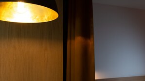 A modern room with a wooden headboard, a bed with white bedding, and a large, round, black pendant light. - Best Western Hotel Spinnerei Linz (Linz)