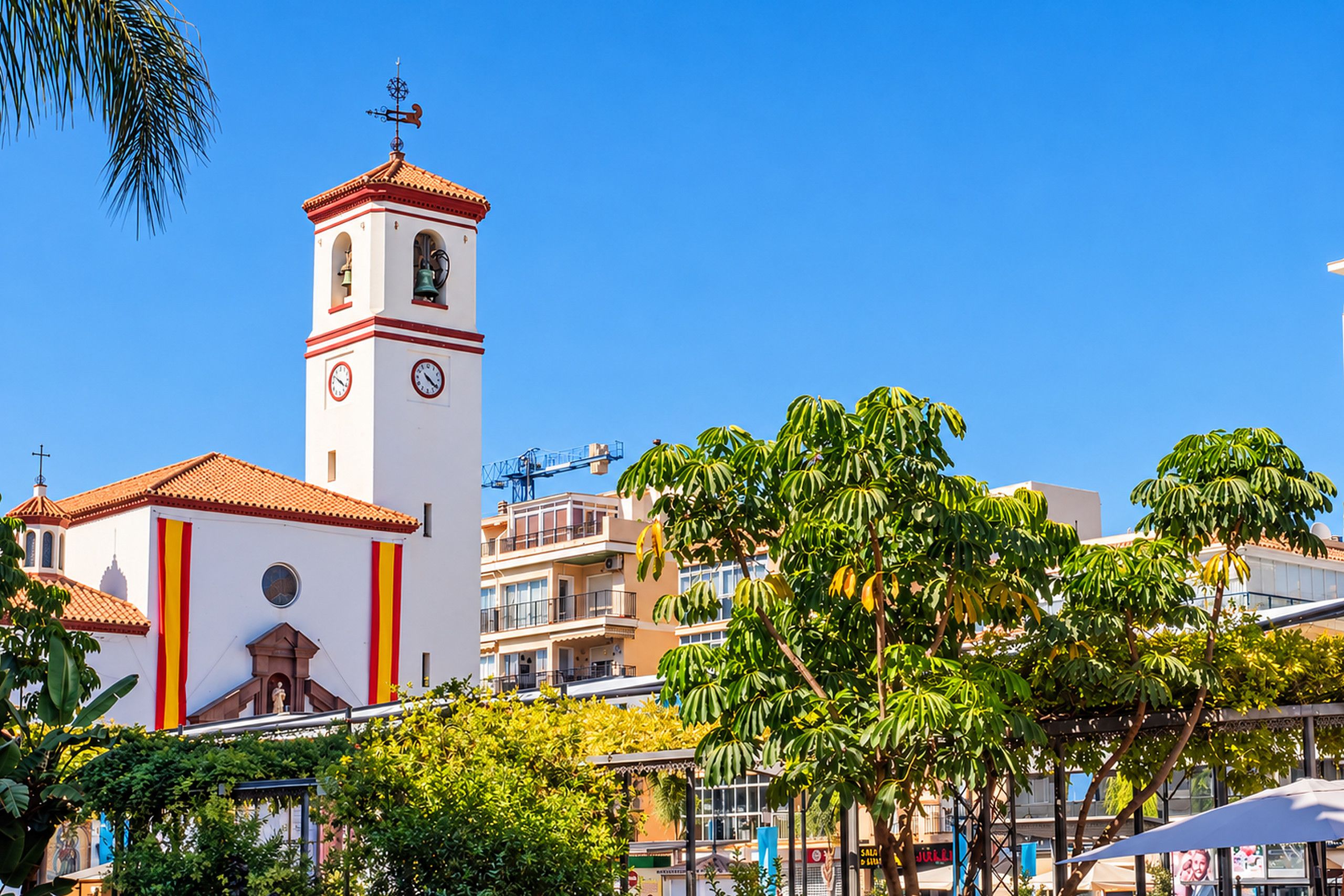 Une église dotée d’un clocher, d’une horloge et d’une façade rouge et blanche.