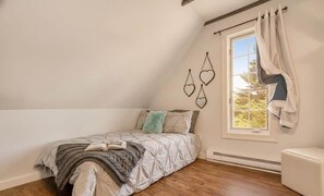 A bedroom with a bed, a window with curtains, and a view of trees outside. - Private Coastal 2-Acre Retreat • Near Lunenburg (Mahone Bay)