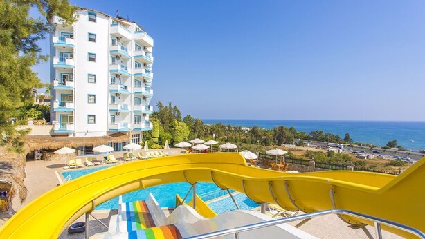Un hotel con piscina, que incluye tobogán y sillas de descanso.