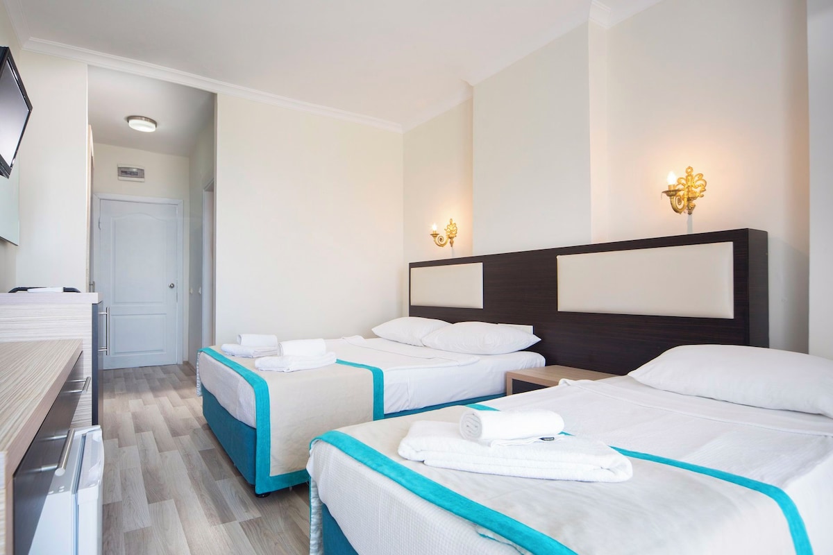 Una habitación de hotel con dos camas, un escritorio y un baño.