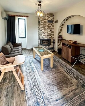 Habitación familiar, 1 habitación | Área de sala de estar | Televisión LCD de 50 pulgadas con canales vía satélite y chimenea 