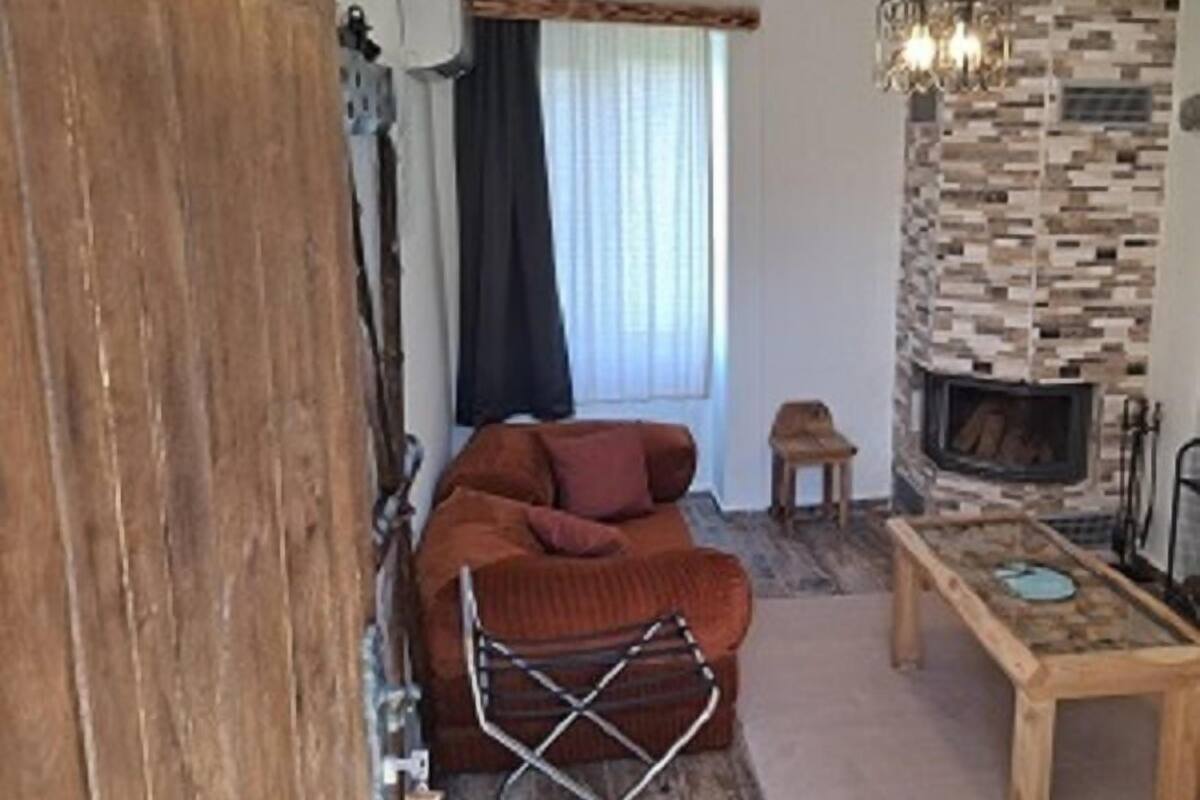 Uma sala de estar com um sofá, uma mesa, uma lareira e uma parede de madeira.