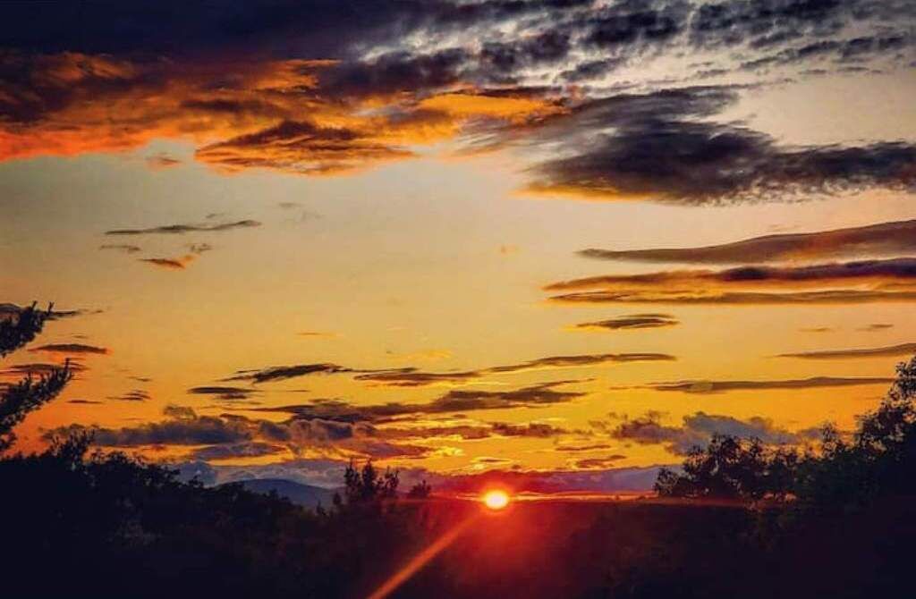 A sunset over a landscape with mountains in the distance.