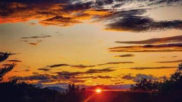 A sunset over a landscape with mountains in the distance.