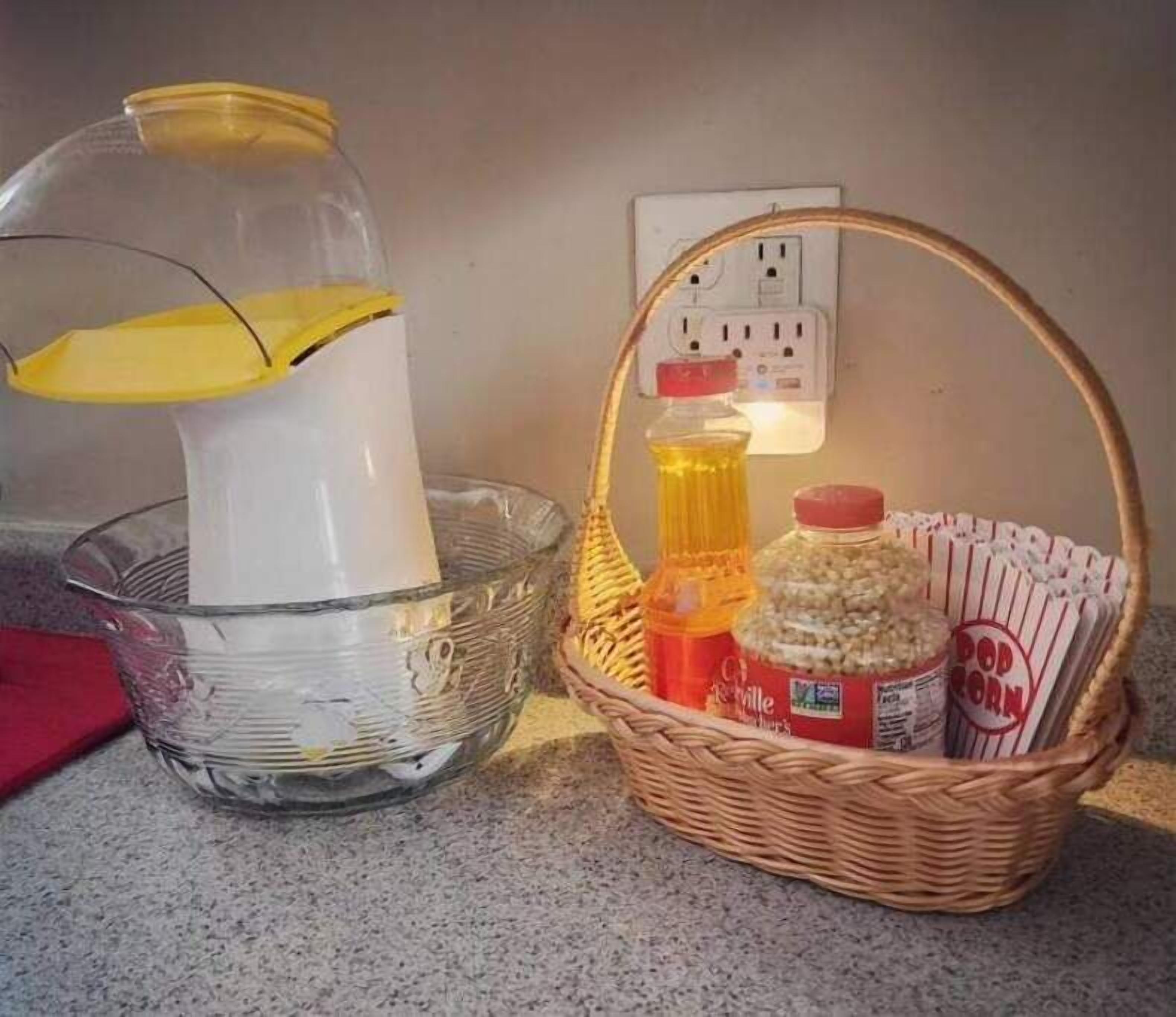 Keittiön työtasolla on lasipurkki, muovipullo ja punottu kori, jossa on popcornia ja purkki sinappia.