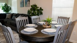 A dining area with a round table set for four, surrounded by six chairs. - Near Airport & Beach Fully Fenced House (Jacksonville)