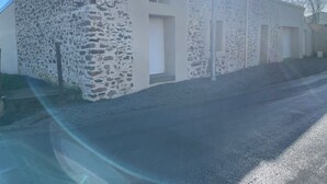 A building with a stone facade and multiple doors, likely a hotel or similar establishment. - Gîte du Pommier 🍎 (Legé)