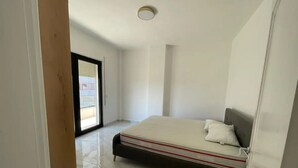 A bedroom with a bed, a window, and a door. - Vollga Apartment 9 (Durrës)