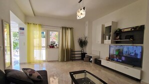 A modern living room with a sofa, a glass coffee table, a TV, and a plant. - Luxury apartment Ani - Three Bedroom Apartment with terrace and Swimming pool (Sutivan)