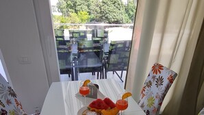 Una mesa de comedor con una revista, un plato de comida y dos vasos de una bebida roja.