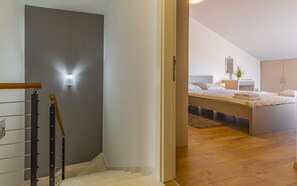 A modern bedroom with a bed, bedside table, and a mirror. - Apartment Leo (Pješčana Uvala)