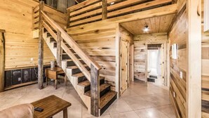 A wooden interior with a staircase leading to a loft area.