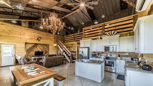 A spacious kitchen with white cabinets, a large island, and stainless steel appliances.