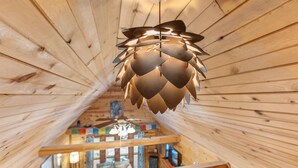 Een houten interieur met een opvallend ventilatorontwerp en een zichtbare trap die naar een hoger gelegen verdieping leidt.