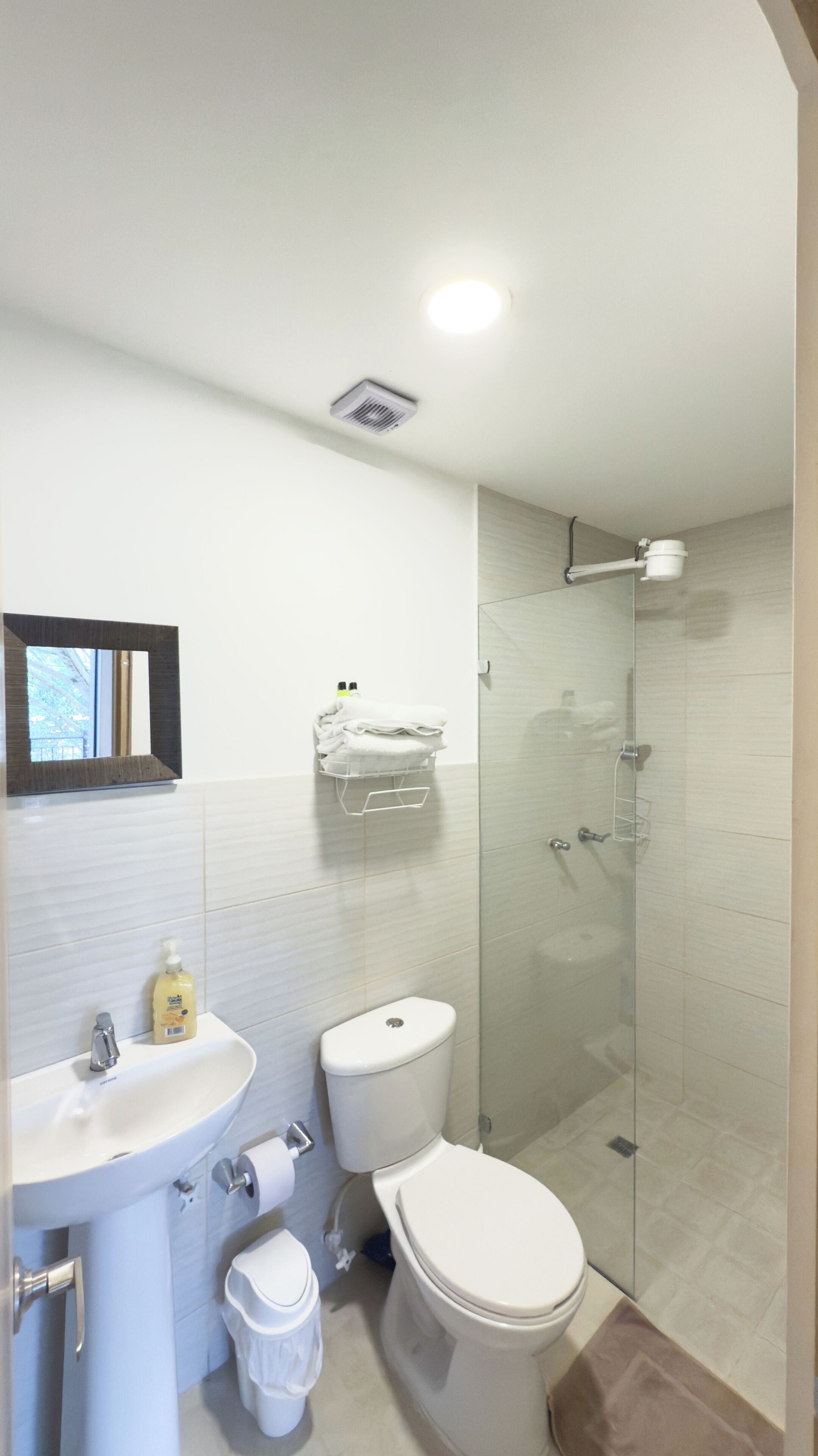 Une salle de bain moderne avec un lavabo, des toilettes et une douche à parois de verre.