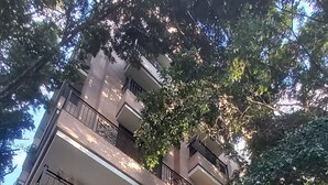 A multi-story building with balconies, arched entrances, and surrounding greenery. - EDIFICIO FENICIA (Medellín)
