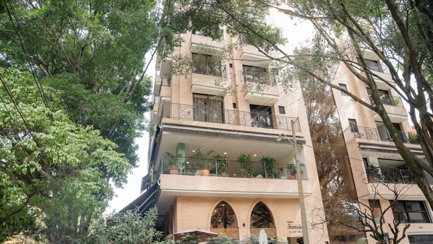 A multi-story building with balconies, arched windows, and potted plants. - EDIFICIO FENICIA (Medellín)