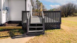A mobile home with a wooden deck and a small outdoor seating area. - Chic and cozy home near the hospital: 3 comfy rooms, TVs, stylish amenities. (Gastonia)