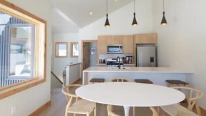 A modern kitchen with wooden cabinets, a central island, and pendant lighting. - Modern Mountain Retreat, 360'Views,Minutes to Trails (Crested Butte)